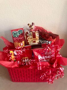 a red basket filled with candy and candies on top of a white countertop