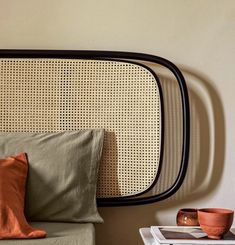 a bed with pillows and a headboard made out of wicker on the wall