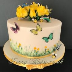 a white cake with yellow roses and butterflies on it