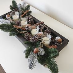 a tray with candles and pine cones on it