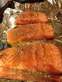 three salmon fillets sitting on top of aluminum foil