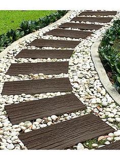 a garden path made out of wood and pebbles