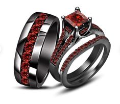 two wedding rings with red stones on them