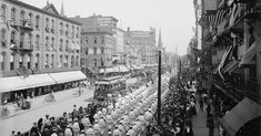 an old black and white photo of people walking down the street