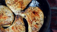 four pieces of chicken cooking in a skillet