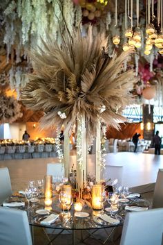 the centerpiece is decorated with feathers, candles and other decorations for an elegant event