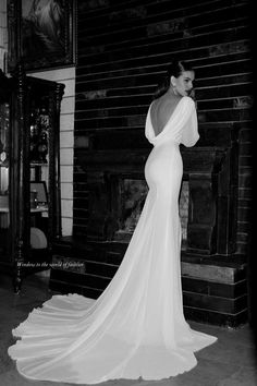 black and white photograph of a woman in a wedding dress looking at the back of her gown