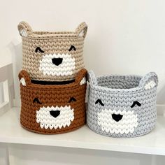 two crocheted baskets sitting on top of a white shelf