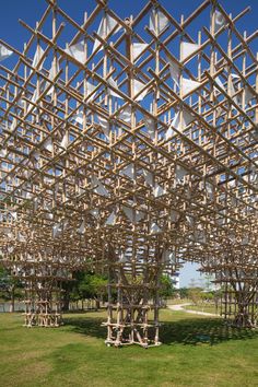 an intricate wooden structure in the middle of a field