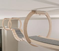 a cat bed hanging from the ceiling in a room with white walls and carpeted flooring