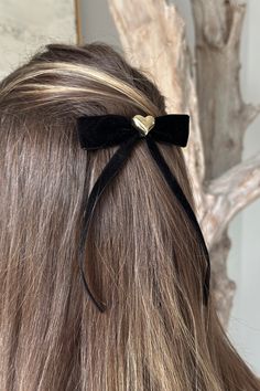 Elevate your hair game with the enchanting Julia Gold Heart Black Velvet Hair Bow. Crafted with finesse, this accessory embodies sophistication and charm. Its centerpiece is a sumptuous self-tied black velvet ribbon bow, exuding elegance with every loop and twist. Adding a touch of opulence, a radiant gold heart medallion detail adorns the center, infusing a hint of glamour into your look. Designed for convenience and style, the clasp closure ensures secure and effortless wear, keeping your hair Elegant Black Hair Accessories With Bow, Black Silk Hair Bow, Black Velvet Hair Bow, Velvet Ribbon Bow, Black Bow Hair Clip, Velvet Hair Bow, Gold Hair Bow, Black Velvet Ribbon, Velvet Hair