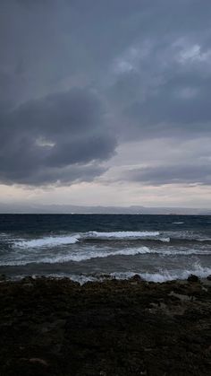 the sky is dark and cloudy over the ocean