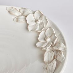 a white plate with flowers and leaves on it