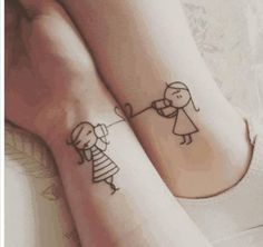 two people holding hands with tattoos on their feet