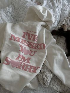 a dog laying on top of a bed next to a white shirt that says i've missed you som sorry