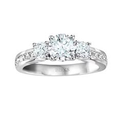 a three stone engagement ring with diamonds on the band and side stones set in 18k white gold