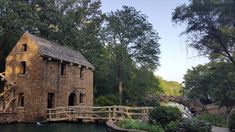 a small house built into the side of a river with a bridge going across it