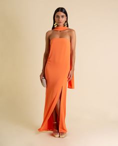 a woman is wearing an orange dress with high slits on the side and one leg