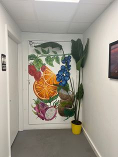 a hallway with a painting on the wall next to a potted plant