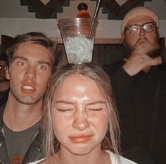 two people standing next to each other in front of a blender on their head