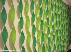 a woman standing in front of a wall with green and white designs on it's side