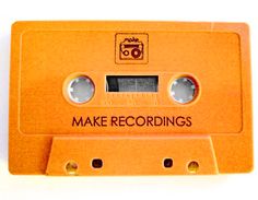 an orange tape recorder with the words make recordings on it's side and two holes in the front