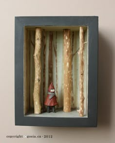 there is a small figurine in a box with some trees around it and a gnome