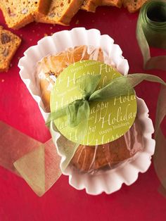 a table topped with slices of bread and fruit on top of paper plates next to green ribbon