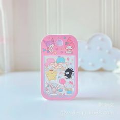 a pink cell phone case sitting on top of a white table next to a stuffed animal