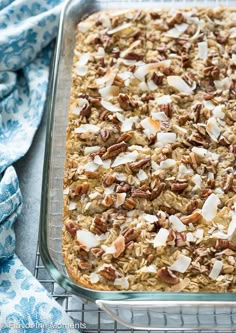 a baked oatmeal in a glass dish on a cooling rack with blue and white cloth