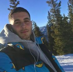 a man wearing headphones standing in the snow