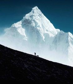 two people standing on top of a snow covered mountain