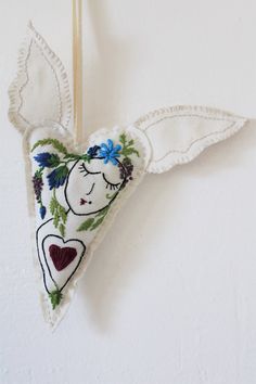 an ornament hanging on a wall with leaves