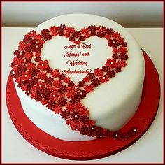 a heart - shaped cake with red flowers and hearts on the top is sitting on a table