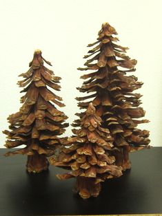 three wooden pine trees sitting on top of a table