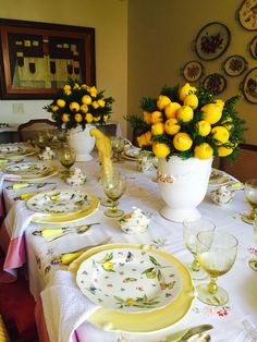 the table is set with lemons and plates