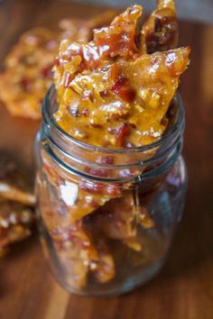 a glass jar filled with candies on top of a wooden table