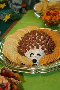 a hedgehog made out of crackers sitting on top of a green table cloth