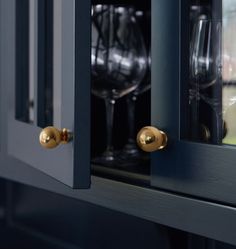 a close up of a wine glass in a cabinet with two glasses on the door