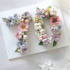 the letter o made out of flowers is on top of a piece of white paper