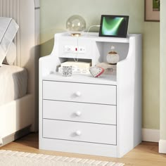 a white dresser with drawers and a computer monitor on top