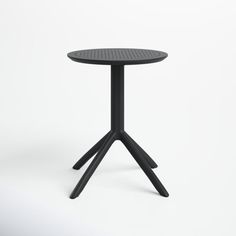 a black table with three legs and a small round table top on it's side