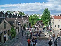 many people are walking up and down the stairs in an old town area with cobblestone streets