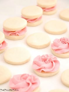 pink and white cookies with frosting on them are arranged in a circle, ready to be eaten