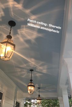 the porch ceiling is painted white and has three lights hanging from it's sides