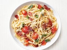 a white bowl filled with pasta covered in tomato sauce