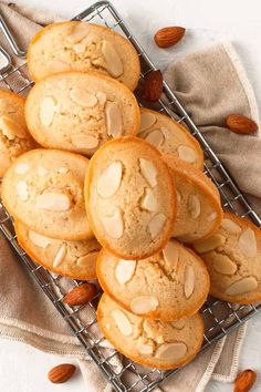 almond muffins on a cooling rack with some almonds in the back ground