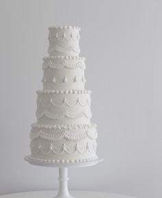 a three tiered white wedding cake sitting on top of a table