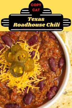 a white bowl filled with chili and cheese next to tortilla chips on a yellow background