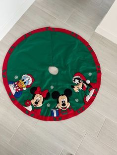 a mickey mouse christmas tree skirt on the floor